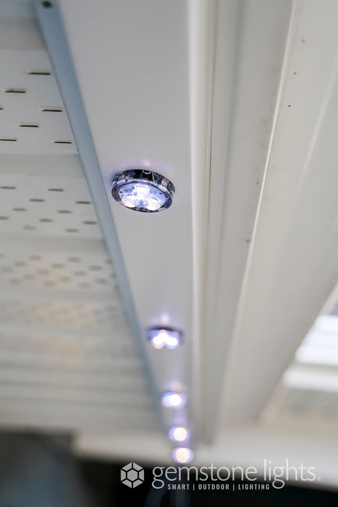 Soft blue lights illuminate a white ceiling-mounted fixture, enhancing a modern aesthetic