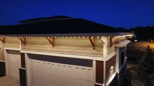 Twinkling lights adorn a home's eaves against a twilight sky