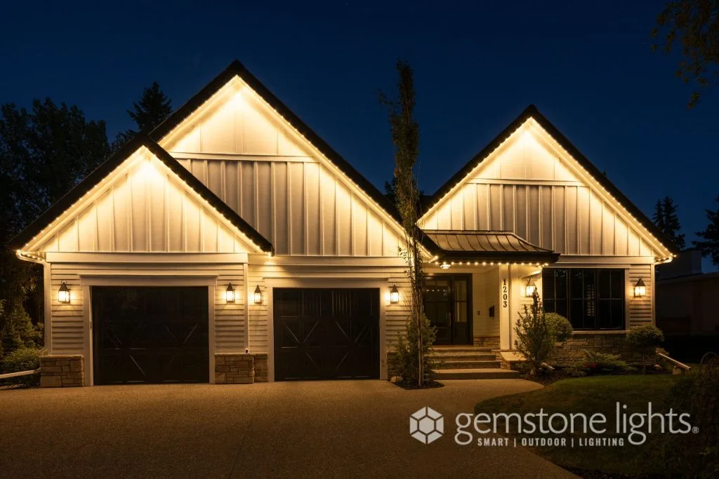 A beautifully illuminated house showcases warm, inviting lights against a night backdrop